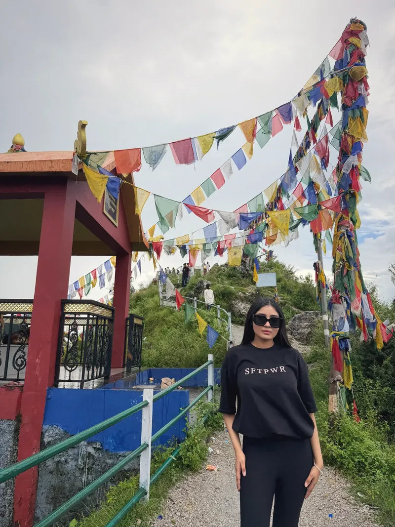SFTPWR co-founder wearing the black tee under prayer flags in the hills
