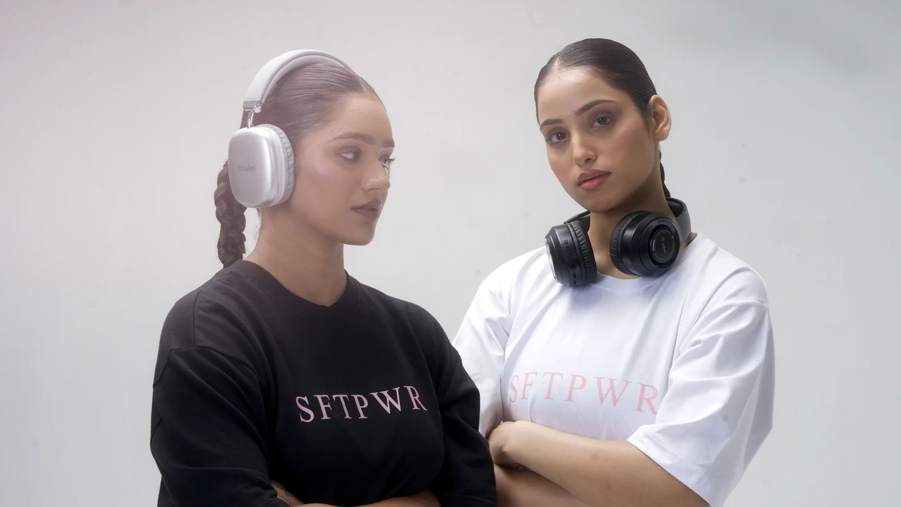 Two women in SFTPWR oversized tees on a Delhi tennis court